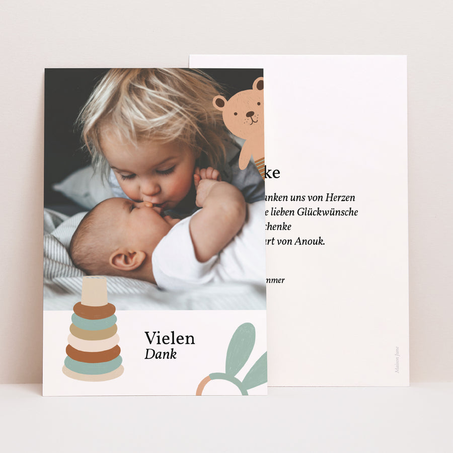 Dankeskarte Geburt PortraitPorträt Schmusetücher und Rasseln foto