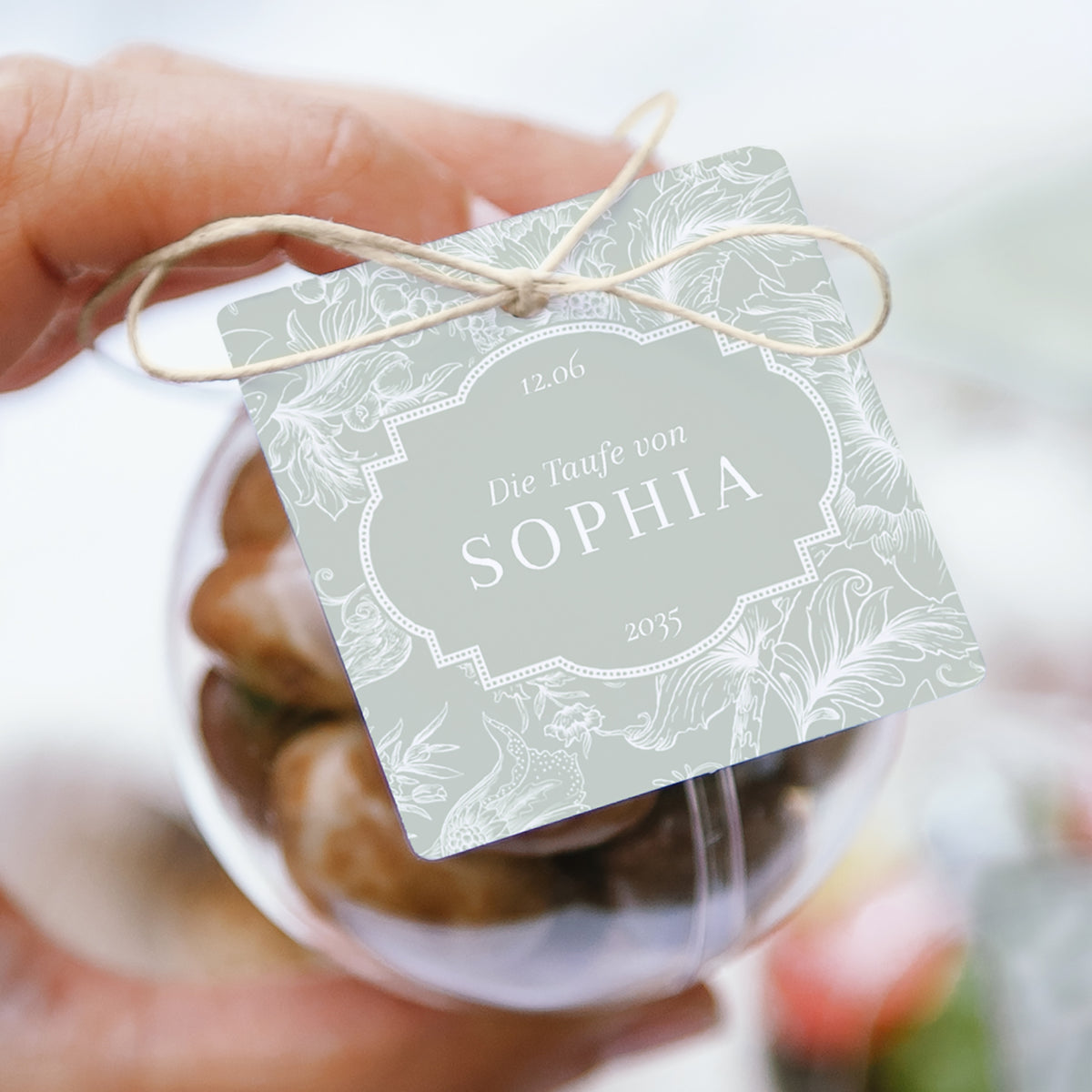 Geschenkbox Taufe Kugel mit quadratischem Etikett Im Garten des Herrn foto